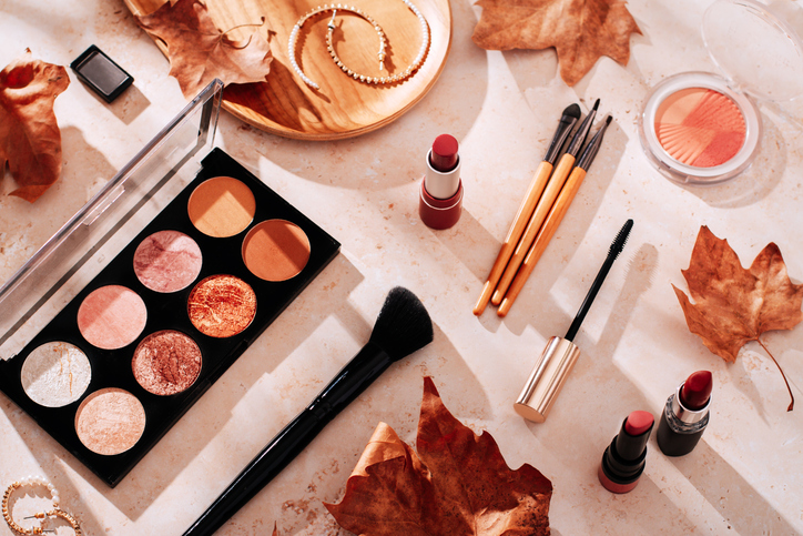 Beauty products and makeup, autumn leaves on beige background